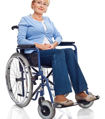Portrait of mature woman sitting in wheelchair and smiling at camera. Studio shot on white background.